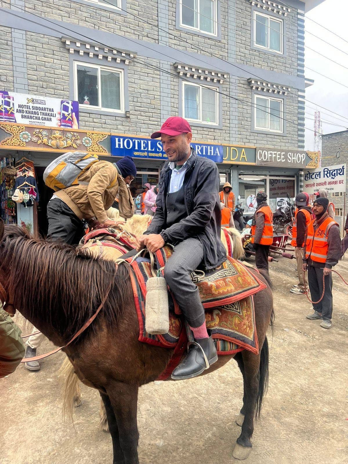 Santosh Sapkota smiling while riding a mule on the trail to Muktinath
