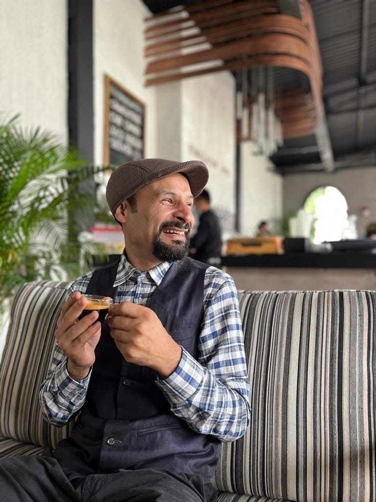 Santosh Sapkota, founder and lead therapist at Healing Hands Nepal, smiling with a cup of coffee