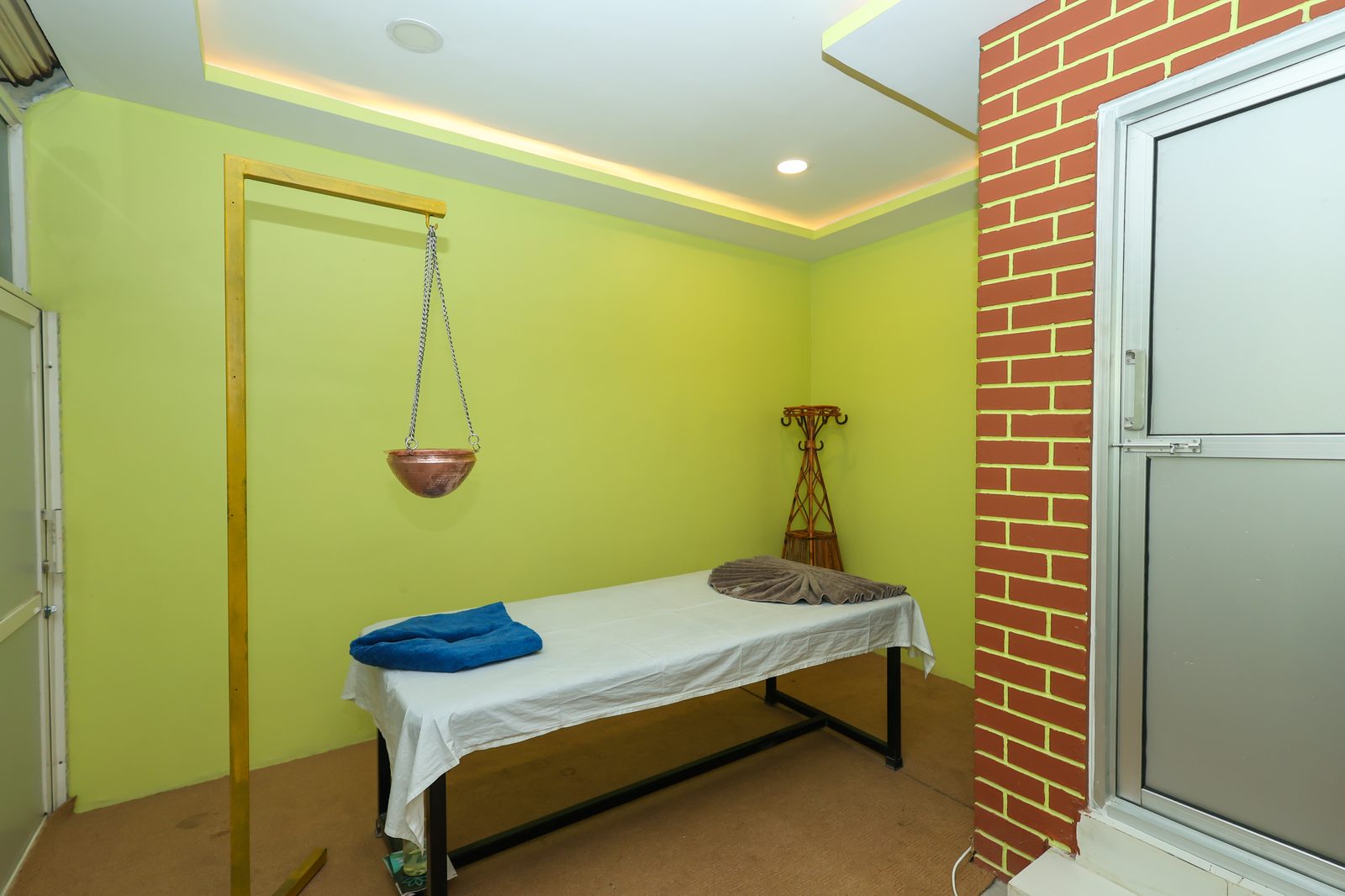 Clean, professional treatment room at Healing Hands Nepal with a massage table and Shirodhara setup